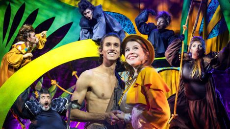 Tarzan und Jane stehen verliebt nebeneinander, während sie von fantasievoll kostümierten Tierfiguren in einem bunten Dschungelambiente umgeben sind.